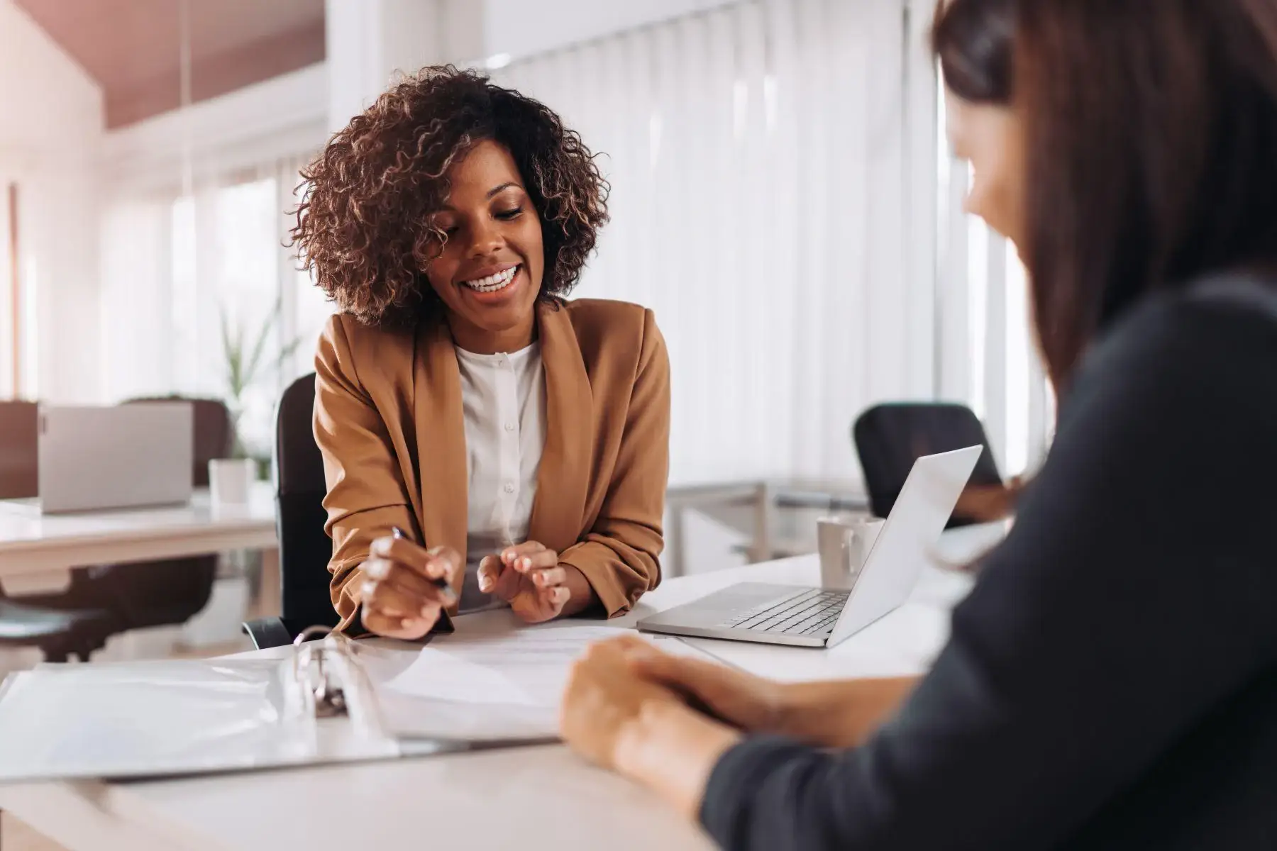 Advisor-discussing-employer-health-benefits-with-client-at-desk.webp